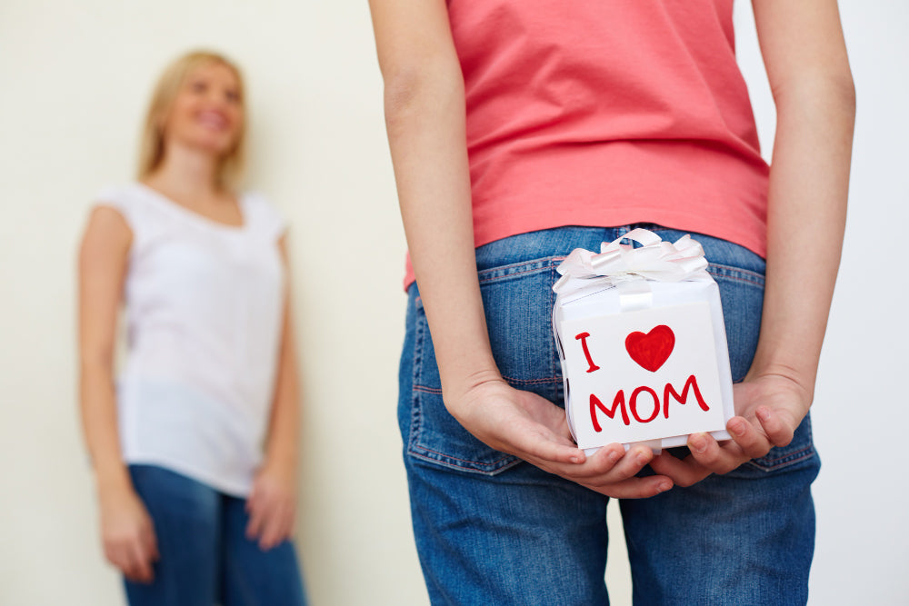mama in hčerka se pogovarjata, deklica drži menstrualni koledar, različni higienični pripomočki, toplotna blazinica Menstra